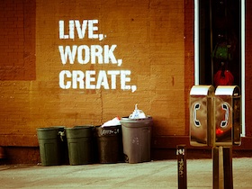 Graffiti on a wall that says, "Live, Work, Create."